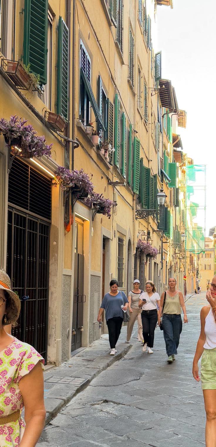 Walking down a Florence lane with green shutters