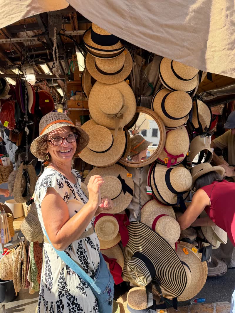 Trying on a straw hat at a Florence market